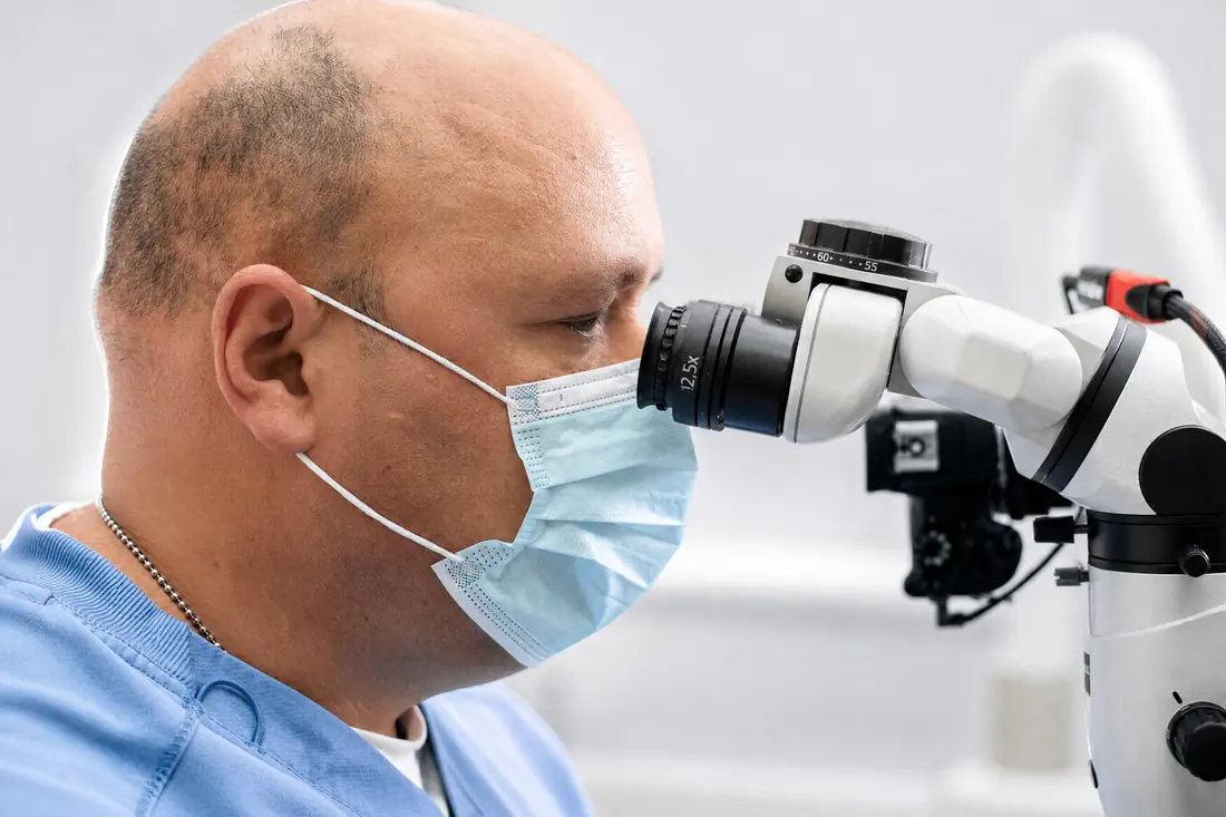 Endodoncista en Caracas usando microscopio clínico durante un tratamiento de conducto